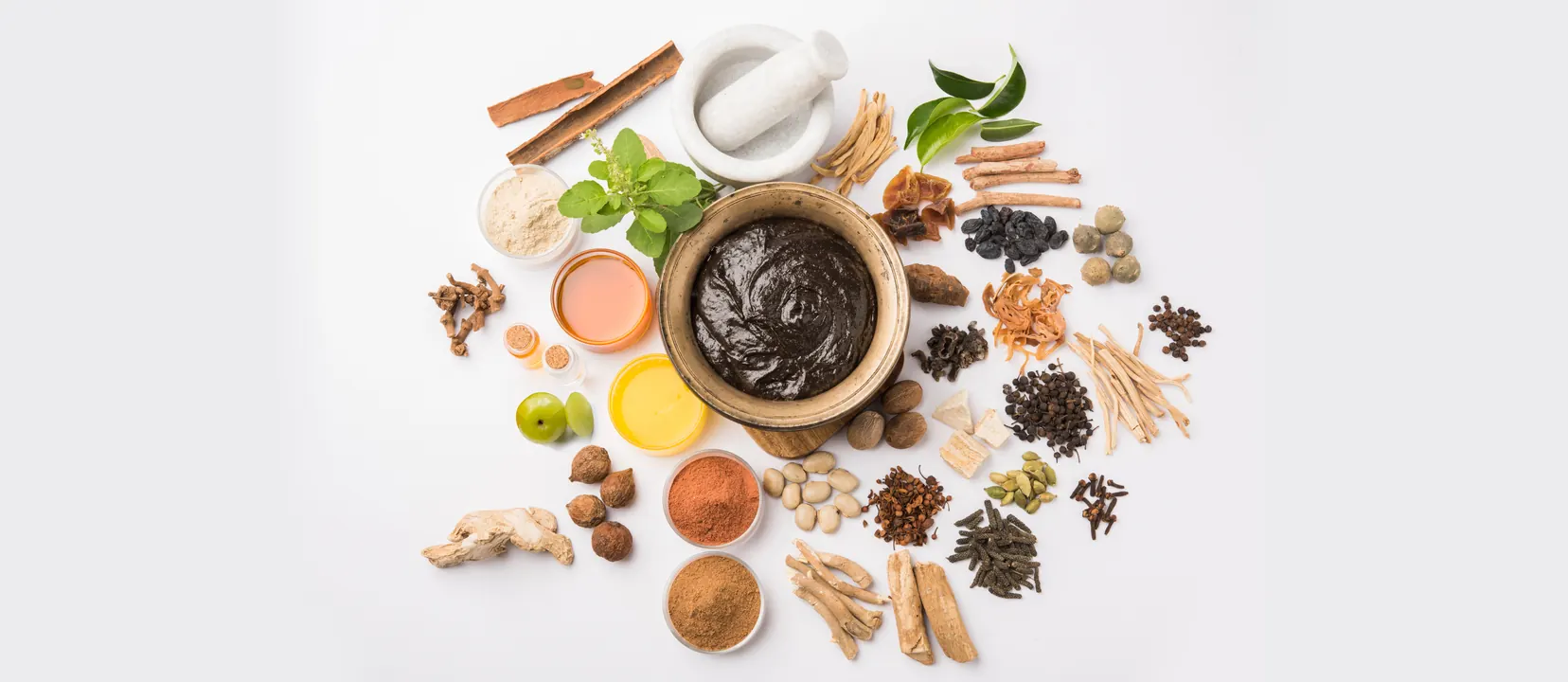 Ayurvedic spices, herbs and powders arranged around a bowl