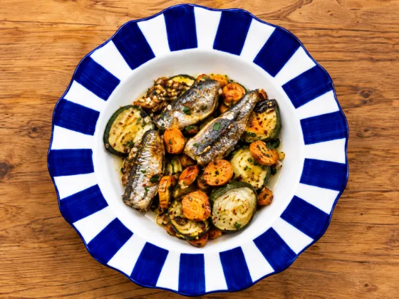 Baked sardines with carrot and zucchini on a blue-and-white striped plate