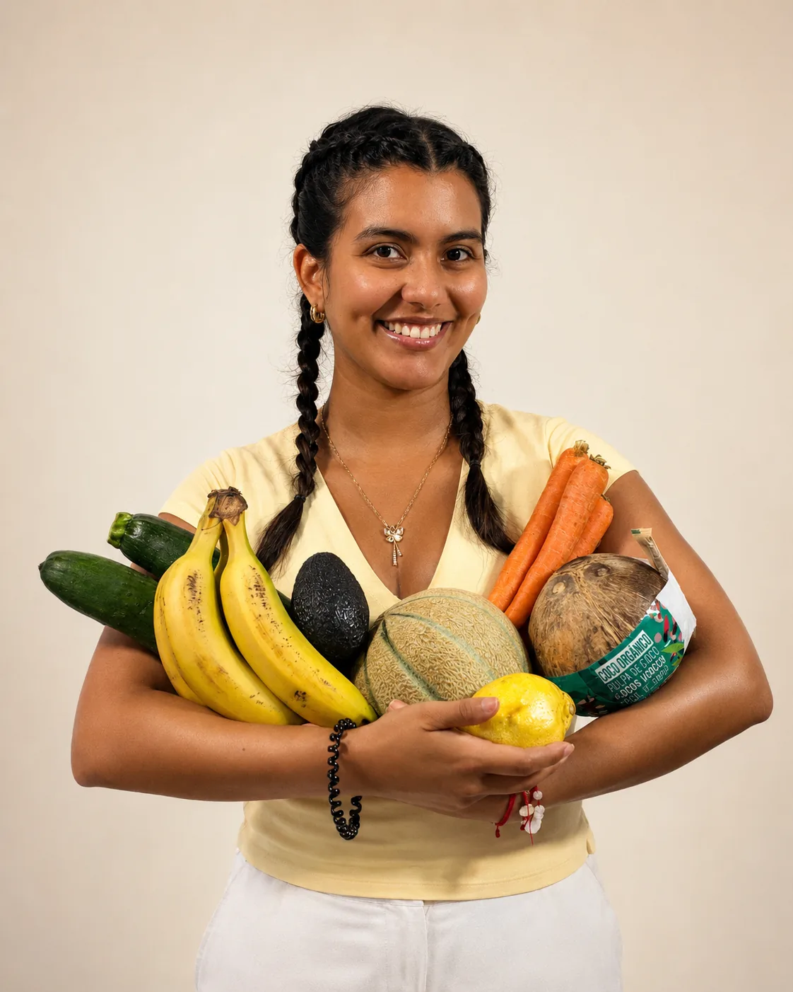 Mariana Arenas Vanegas holding an armful of fresh fruit and vegetables