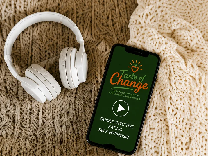 White headphones beside a phone showing the Taste of Change guided audio player